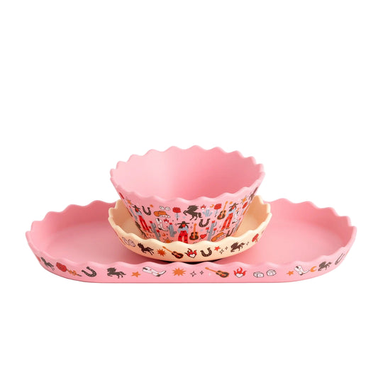 Set of pink children's bowls and plates with cartoon designs on a white background
