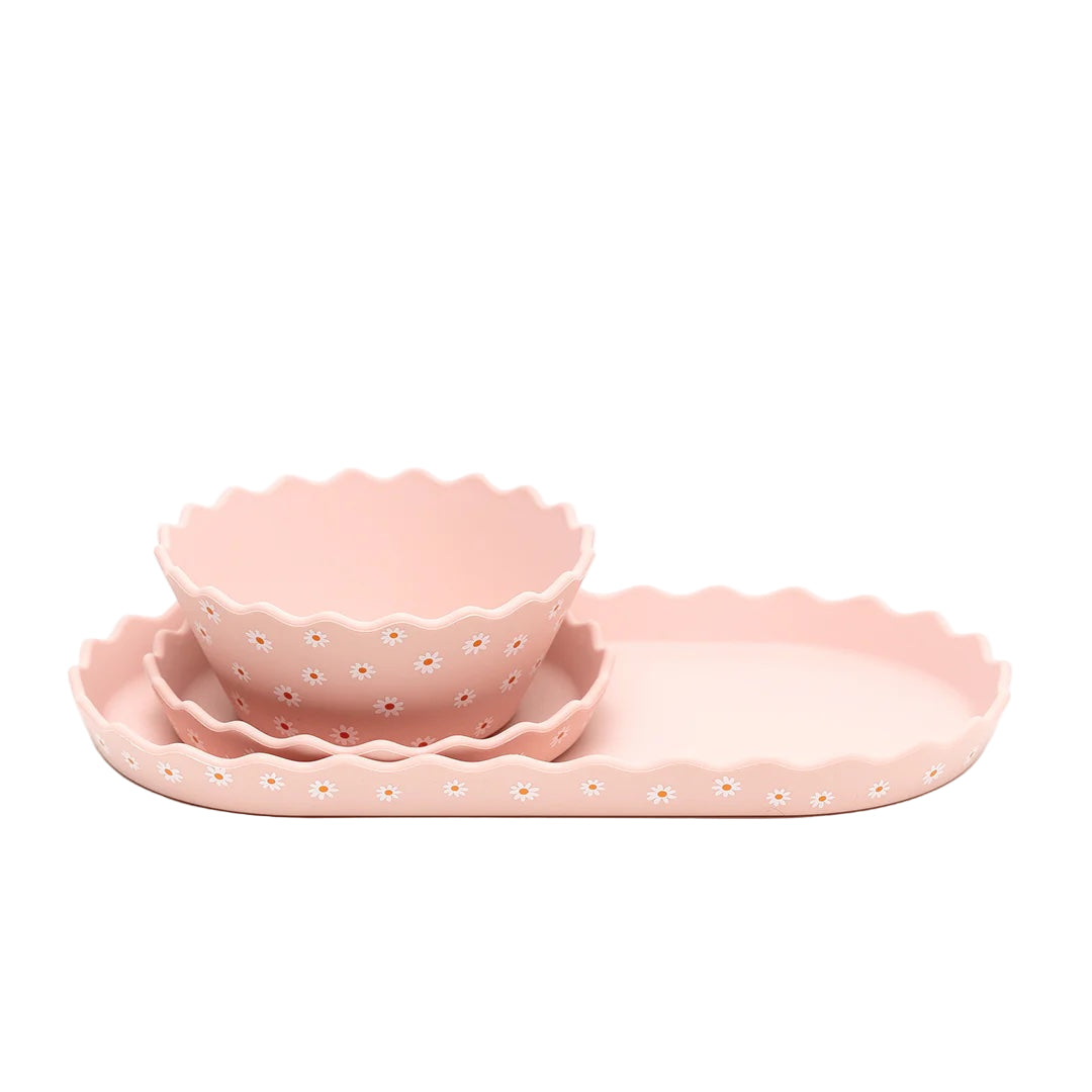 Set of pink ceramic dishes with scalloped edges on a white background