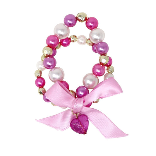 A pink and magenta beaded bracelet with faux pearls, faceted gold beads, and a large light pink satin bow with a dangling heart charm, shown on a plain white background.