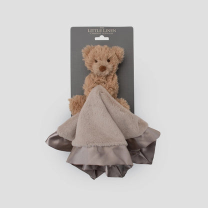 Brown teddy bear with a matching blanket on a gray card against a white background