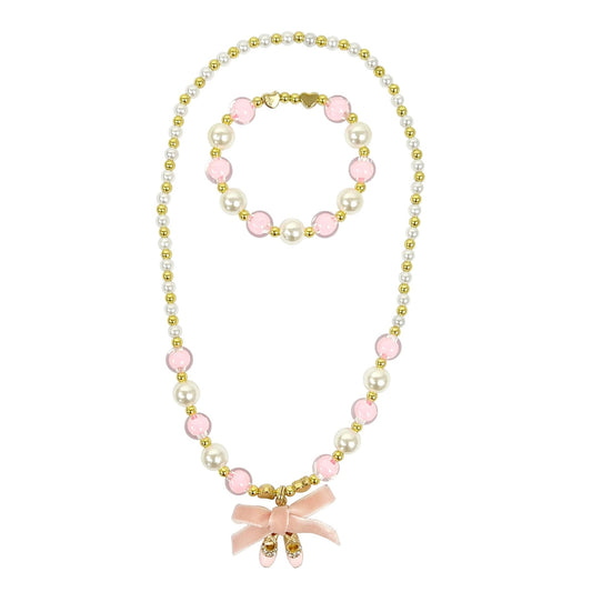 A matching pearl and pink bead necklace and bracelet set with gold-tone metal, featuring a pink ribbon bow charm on the necklace.
