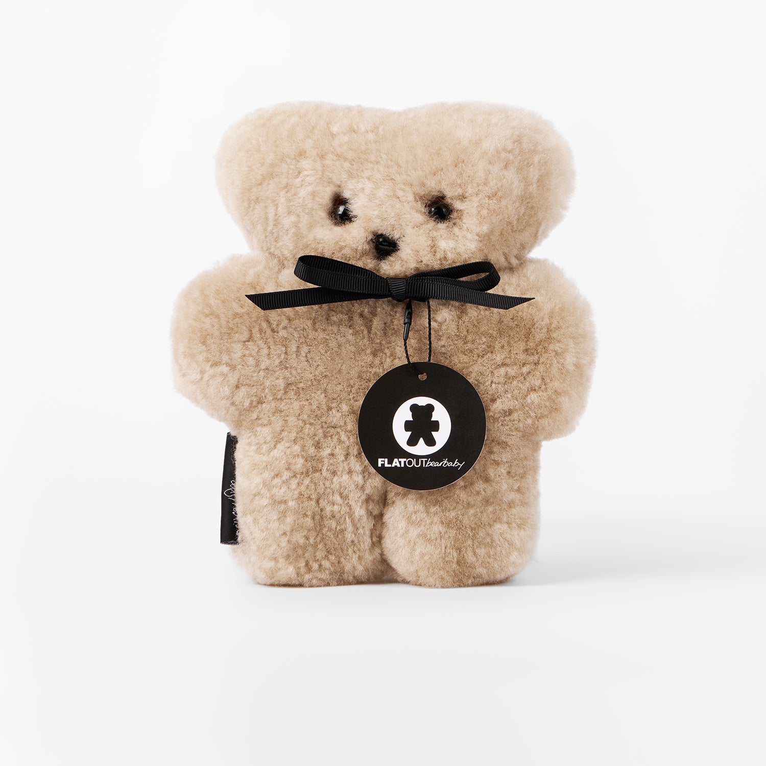 Beige teddy bear with a black bow and 'FLATOUT Stuffed' tag on a white background