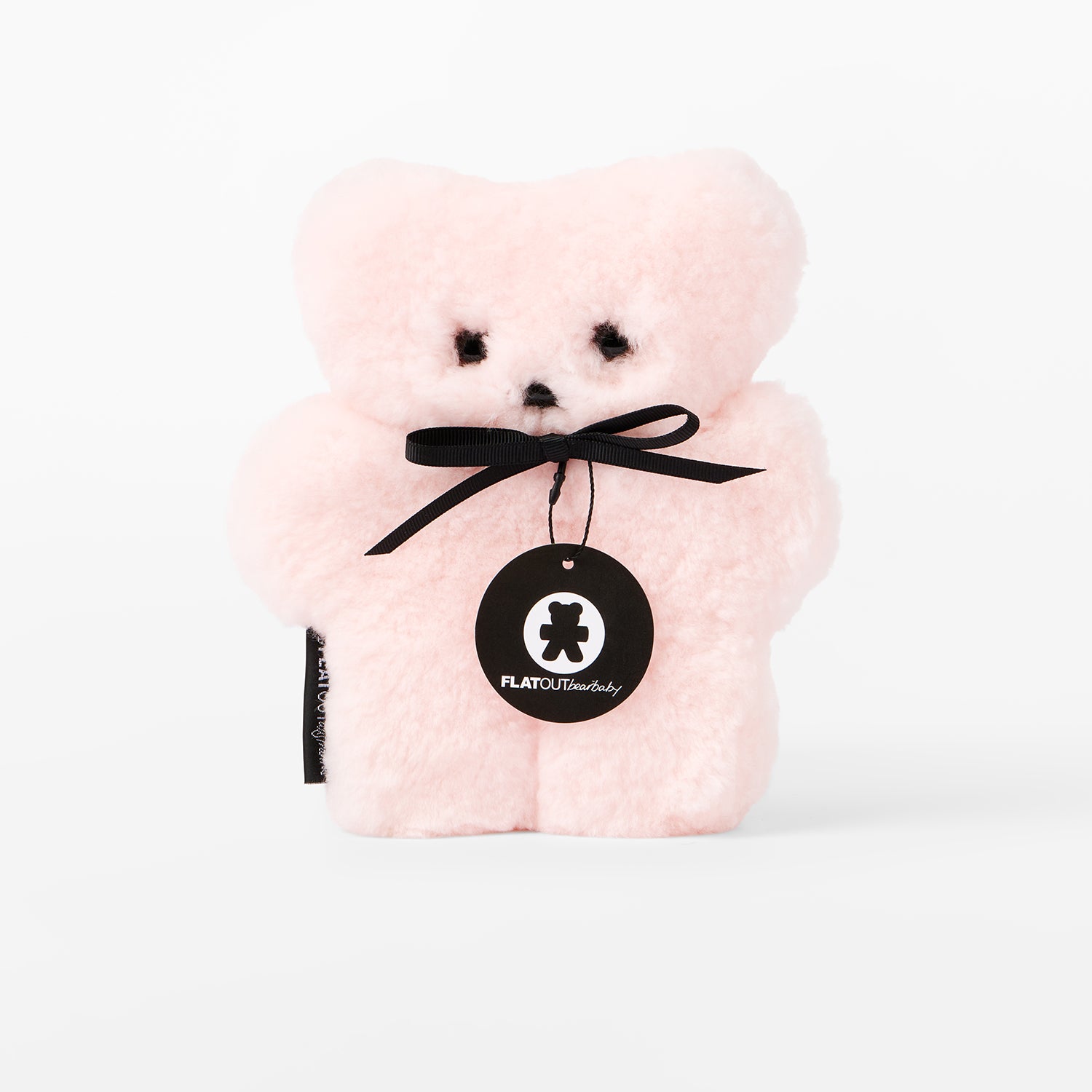 Pink teddy bear with a black ribbon and tag on a white background