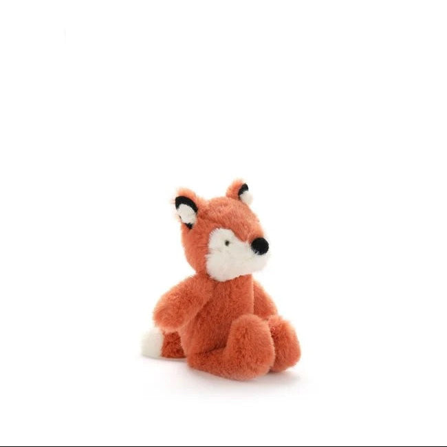 A small plush fox toy in rust orange with a white muzzle, black nose, and black-and-white ears, sitting on a clean white background.