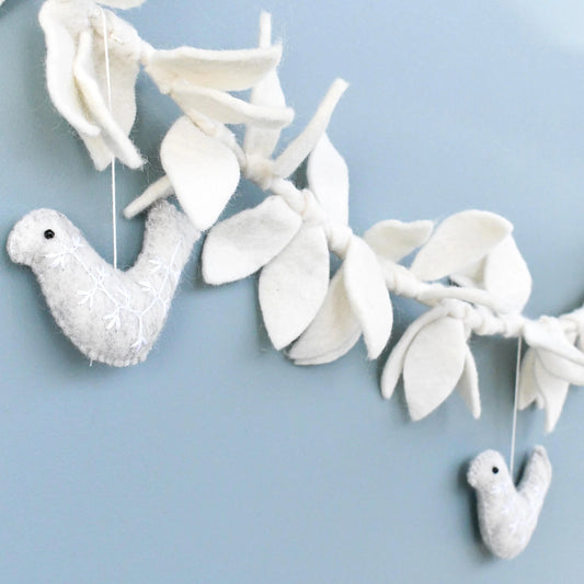 Decorative white bird and leaf garland on a light blue background