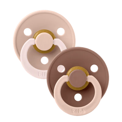 Two baby pacifiers in beige and brown on a white background