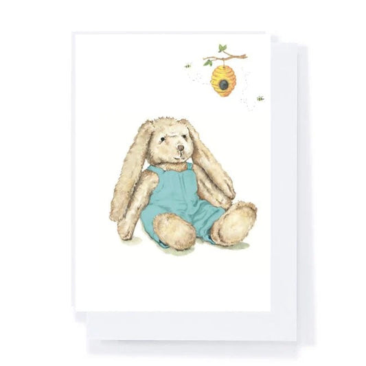 Illustration of a bunny in a blue outfit with a beehive on a white background
