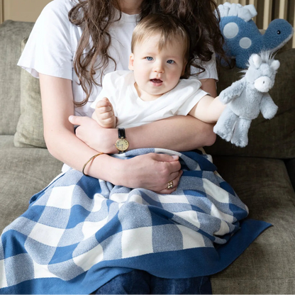 Woman holding a baby with toys in a home setting