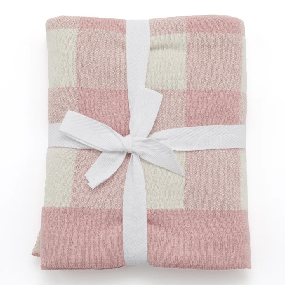 Pink and white checkered blanket with a white ribbon on a white background