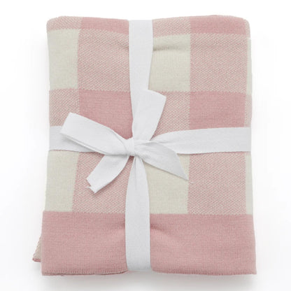 Pink and white checkered blanket with a white ribbon on a white background
