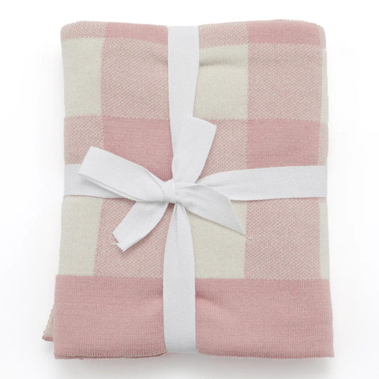Pink and white checkered blanket with a white ribbon on a white background