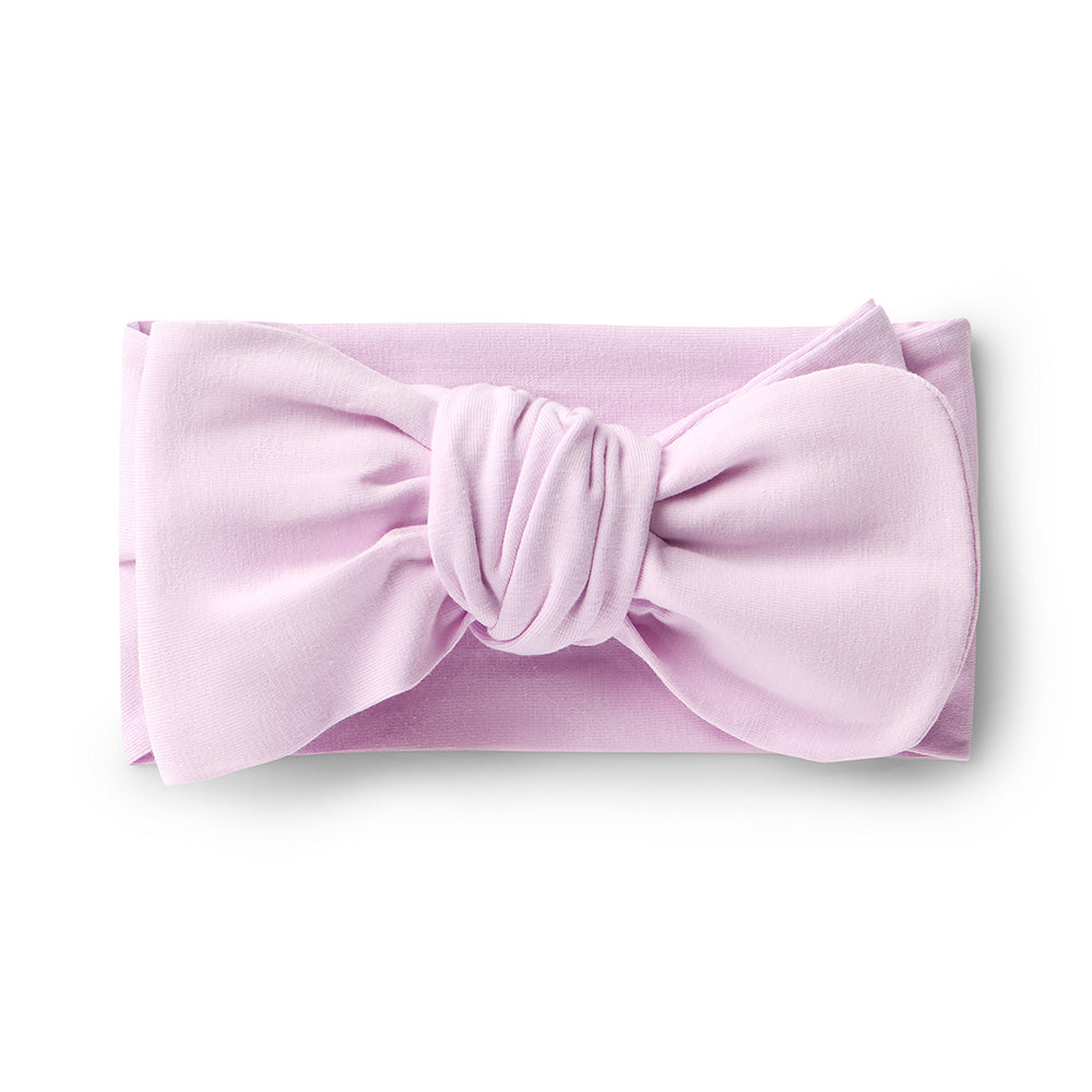 Pink headband with a large bow on a white background