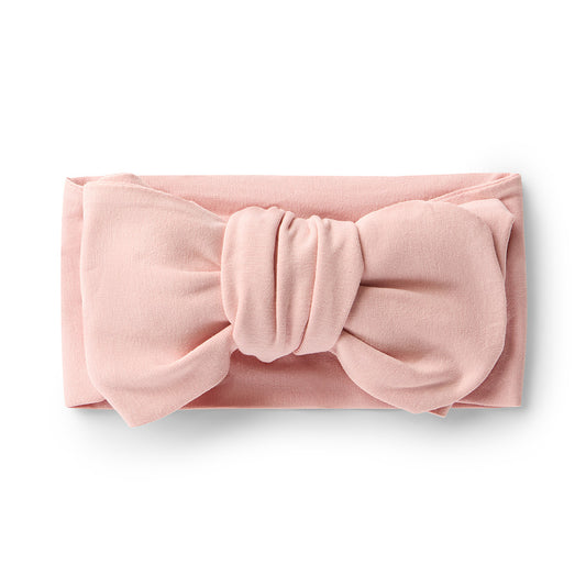 Pink headband with a large bow on a white background