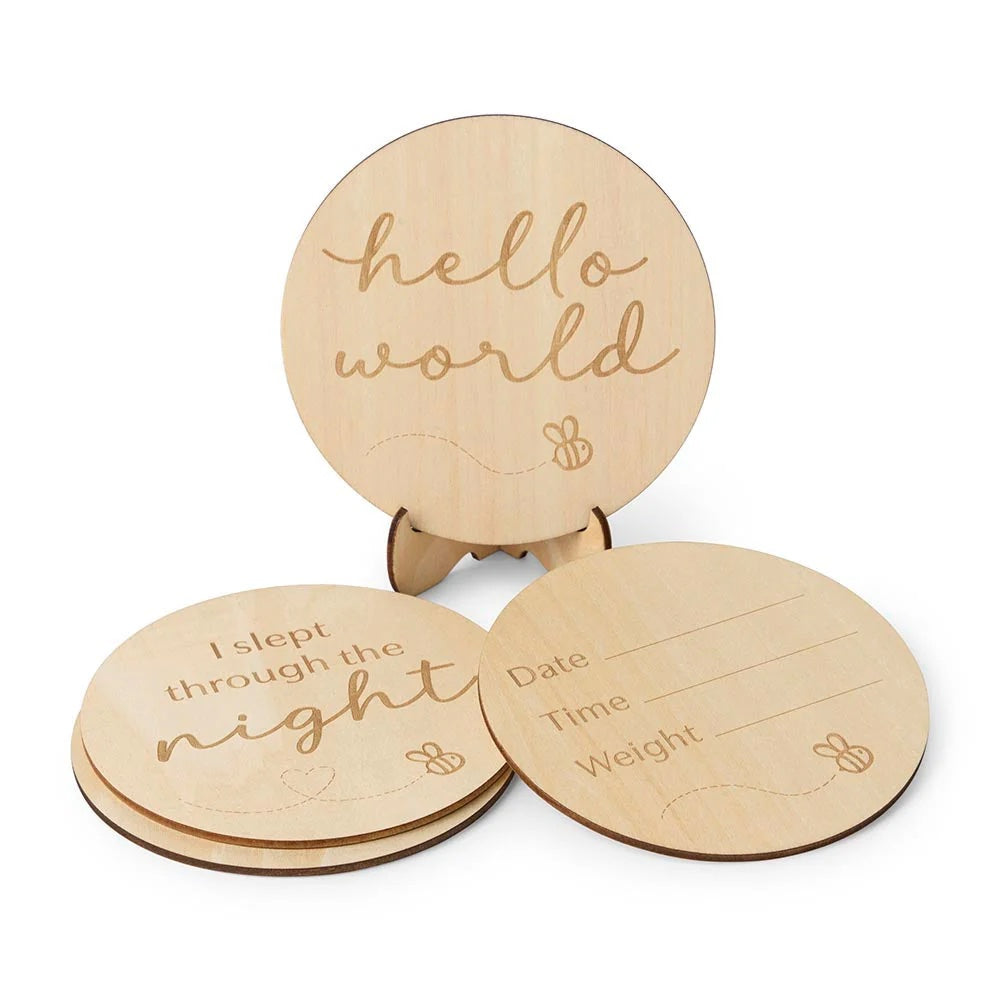 Three wooden discs with engraved text on a white background