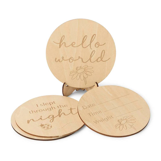 Three wooden discs with engraved text and designs on a white background