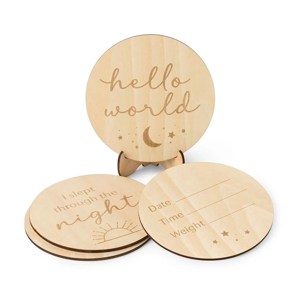 Three wooden discs with engraved text and designs on a white background