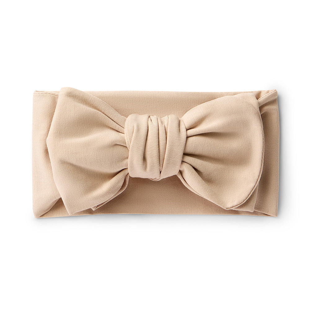 Beige headband with a large bow on a white background