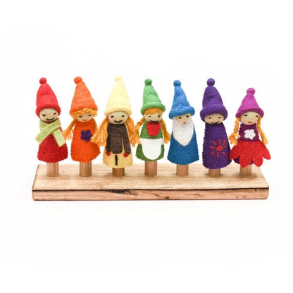 Set of colorful knitted dolls with hats and scarves on a wooden stand.
