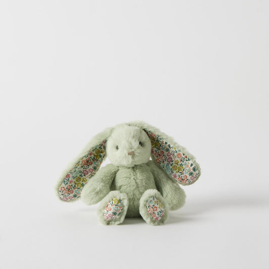 Green plush bunny with floral ears on a light gray background