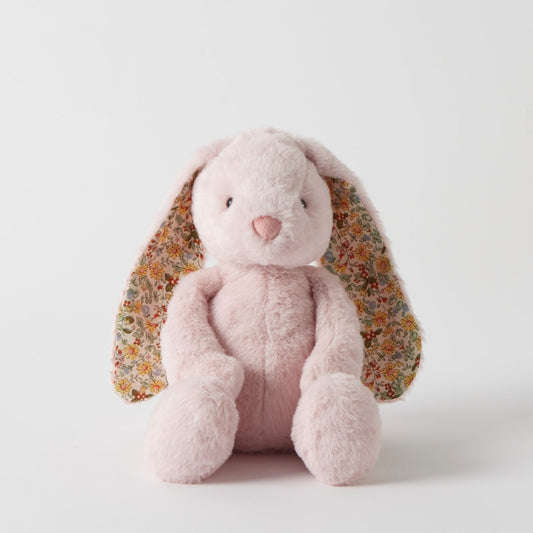 Pink plush bunny with floral ears on a white background