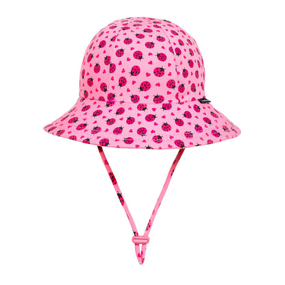 Pink sun hat with ladybug pattern on a white background