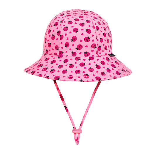 Pink sun hat with ladybug pattern on a white background