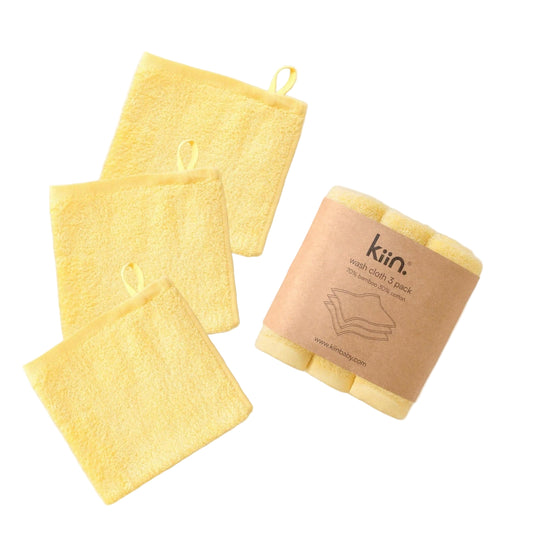 Yellow washcloths with a branded paper bag on a beige background